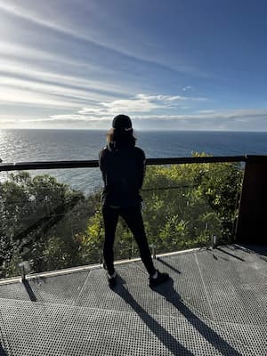 author standing on edge of cliff looking out at ocean