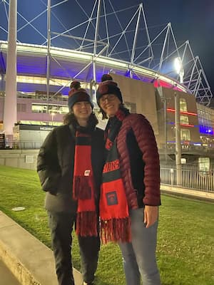 author standing with mother outside stadium