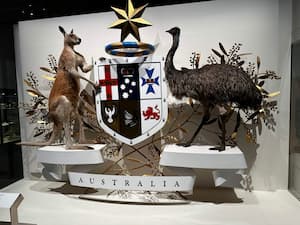 emu and kangaroo standing beside an australia sign