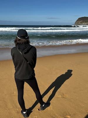 author standing with back turned to camera facing ocean