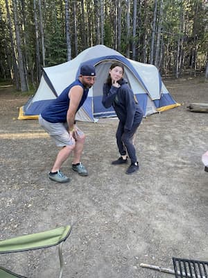 author and her father posing outside of their pitched tent
